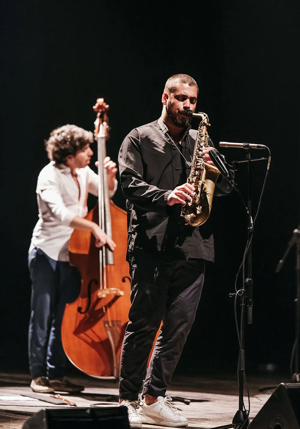 Dois homens a tocar saxofone e contrabaixo